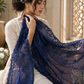 Woman holding a blue lace scarf in an indoor setting