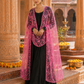 Woman in a black dress with a pink dupatta standing in an ornate architectural setting.