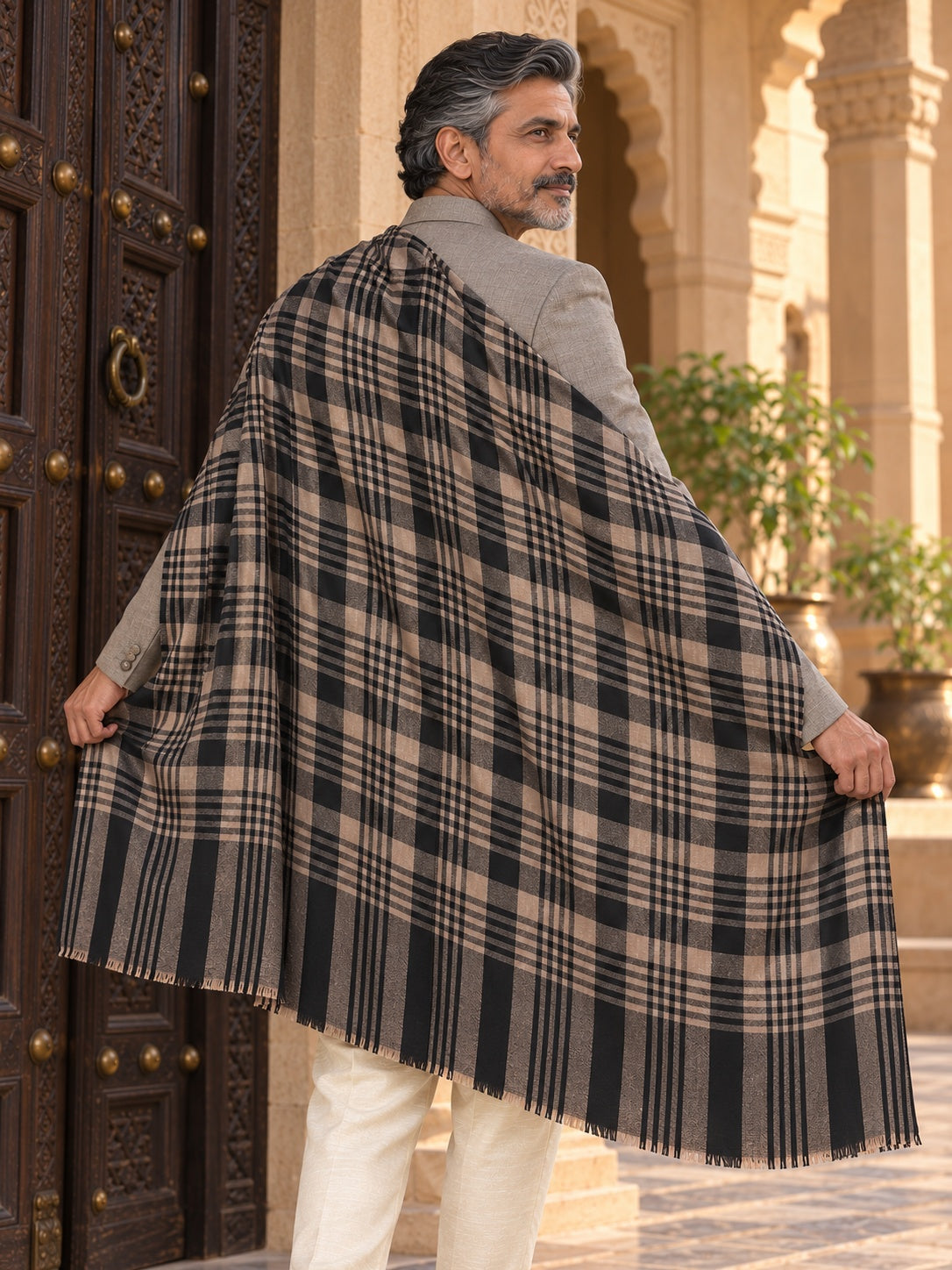 Weavers Villa MS-CHECKS-BLACK men's shawl styled on a premium model in a royal setting, view 3.