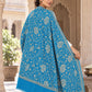 Ferozi blue patterned shawl in an elegant rear drape on a female model in an Indian heritage haveli