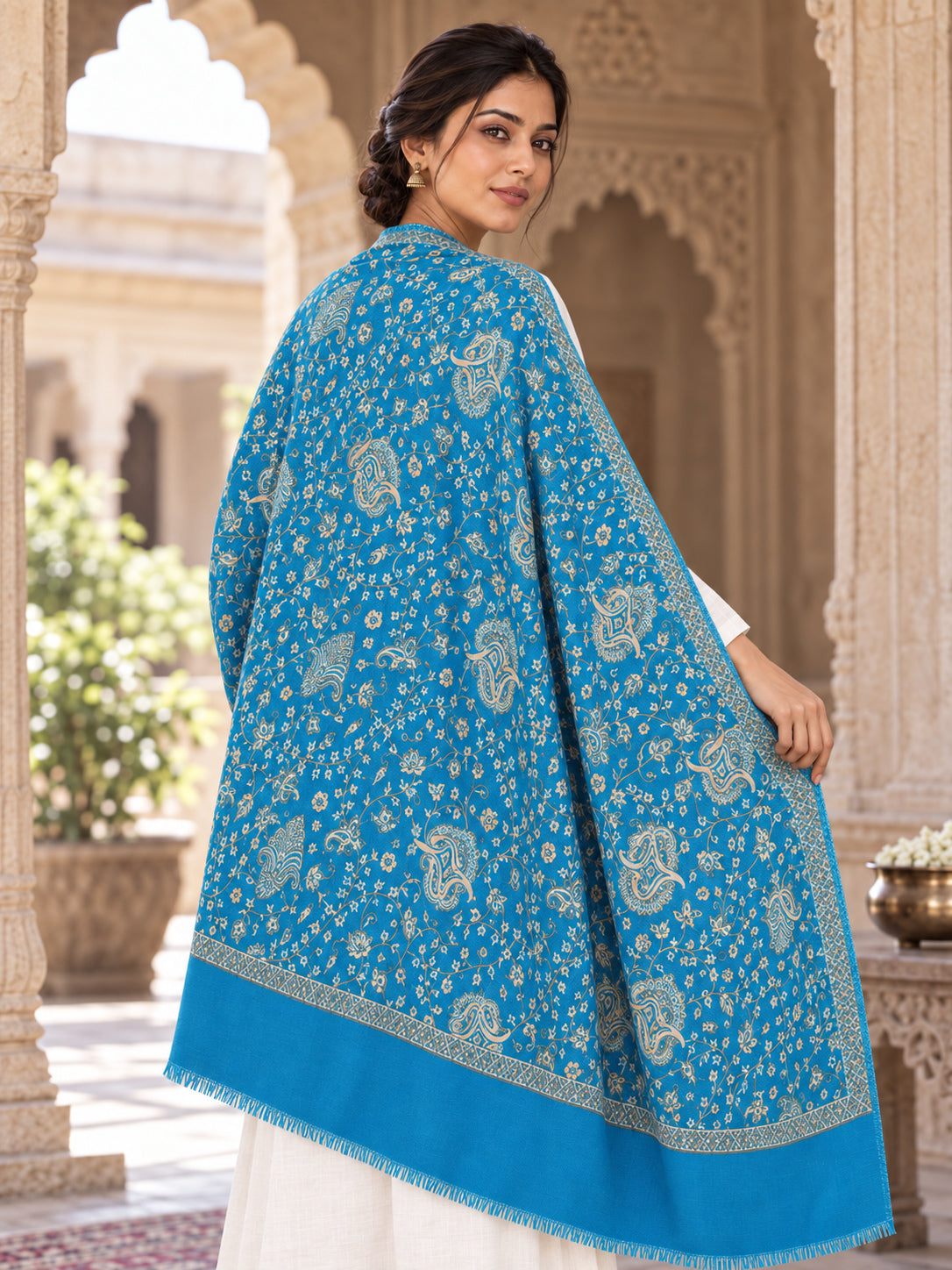 Ferozi blue patterned shawl in an elegant rear drape on a female model in an Indian heritage haveli