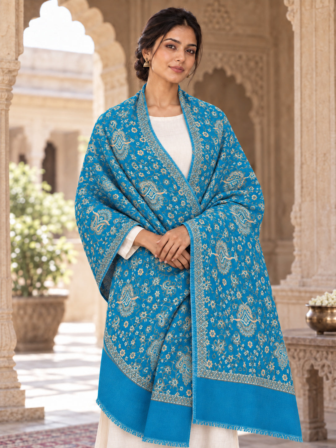 Ferozi blue patterned shawl in an elegant front crossed wrap on a female model in an Indian heritage haveli
