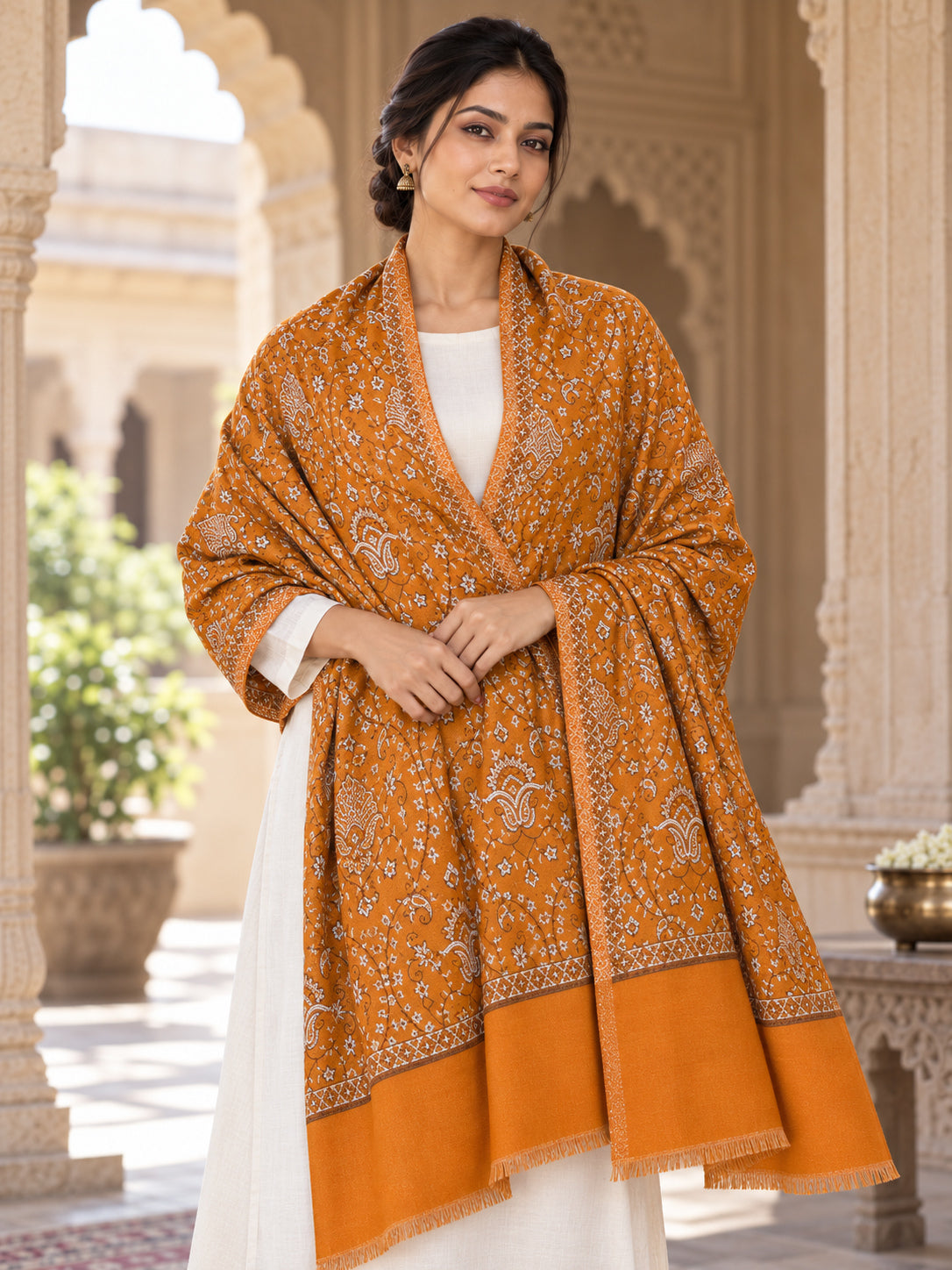 Mustard patterned shawl in an elegant front wrap on a female model in a heritage haveli