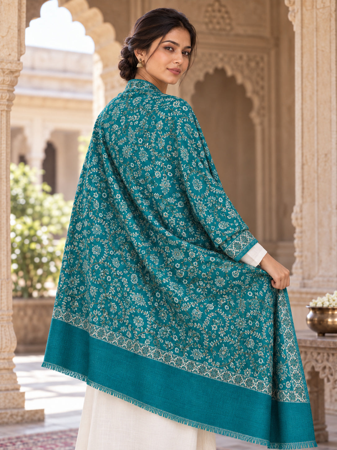 Green patterned shawl in an elegant rear drape on a female model in an Indian heritage haveli