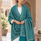 Green patterned shawl in an elegant front crossed wrap on a female model in an Indian heritage haveli
