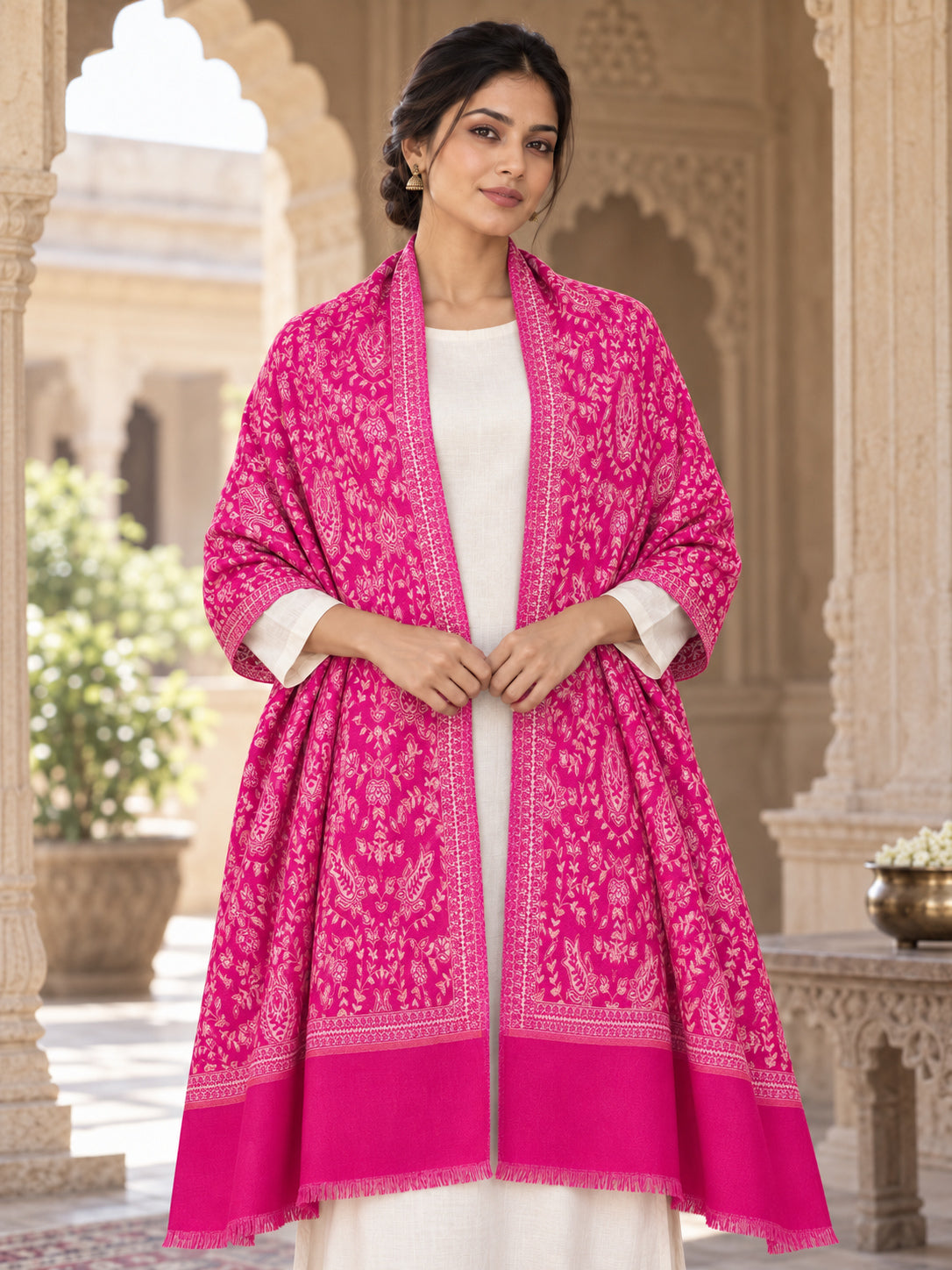 Rani pink patterned shawl in an elegant open shoulder drape on a female model in an Indian heritage haveli