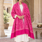 Rani pink patterned shawl in an elegant front crossed wrap on a female model in an Indian heritage haveli