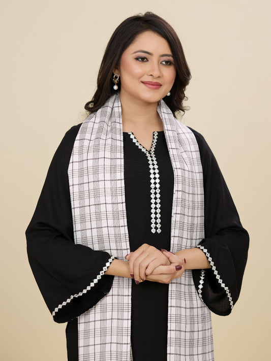 Woman wearing a black and white checkered scarf with a plain background