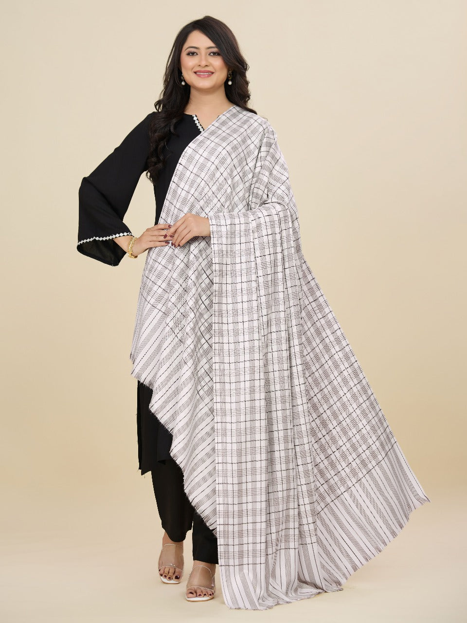 Woman wearing a black and white checkered saree with a plain background