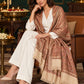 Beige paisley woven shawl styled on a model in a luxurious festive palace setting — seated salon