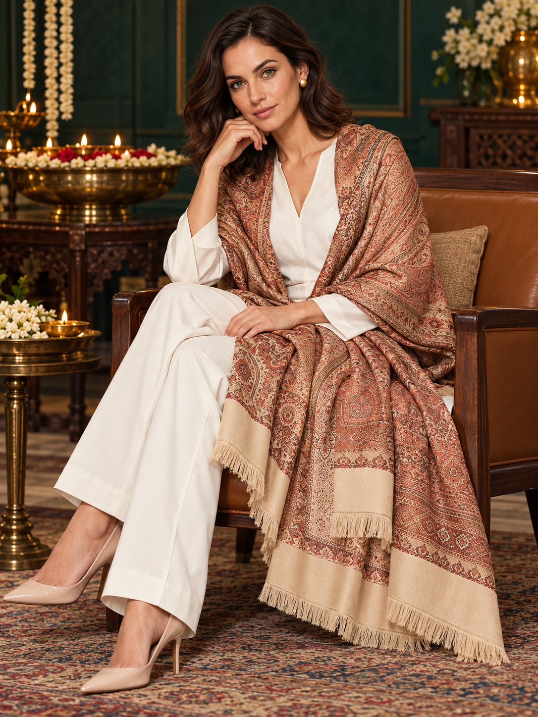 Beige paisley woven shawl styled on a model in a luxurious festive palace setting — seated salon
