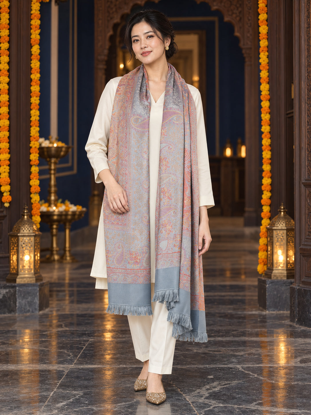 Grey paisley woven shawl styled on a model in a luxurious festive palace setting — long stole