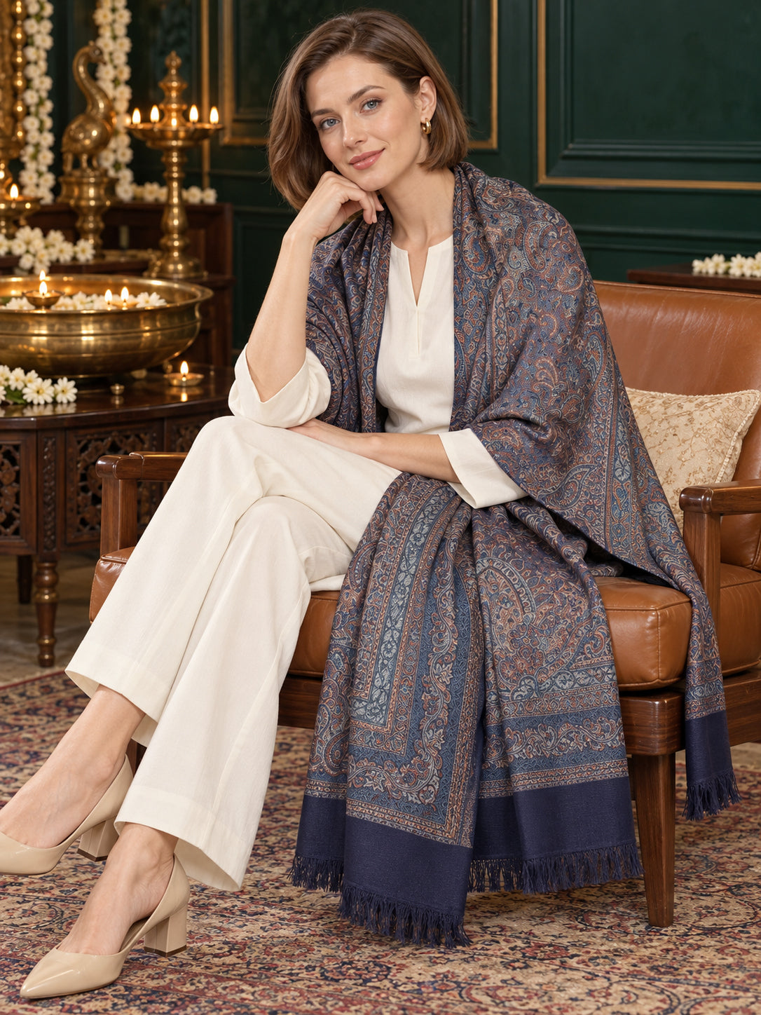 Navy Blue paisley woven shawl styled on a model in a luxurious festive palace setting — seated salon