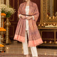 Peach paisley woven shawl styled on a model in a luxurious festive palace setting — belted wrap