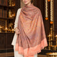 Peach paisley woven shawl styled on a model in a luxurious festive palace setting — single-shoulder styling