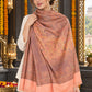 Peach paisley woven shawl styled on a model in a luxurious festive palace setting — detailed shoulder wrap