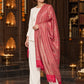 Pink paisley woven shawl styled on a model in a luxurious festive palace setting — single-shoulder styling