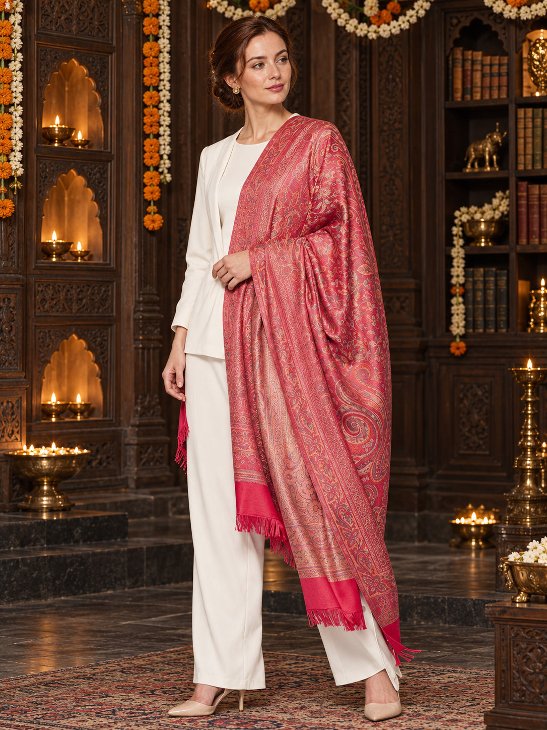 Pink paisley woven shawl styled on a model in a luxurious festive palace setting — single-shoulder styling